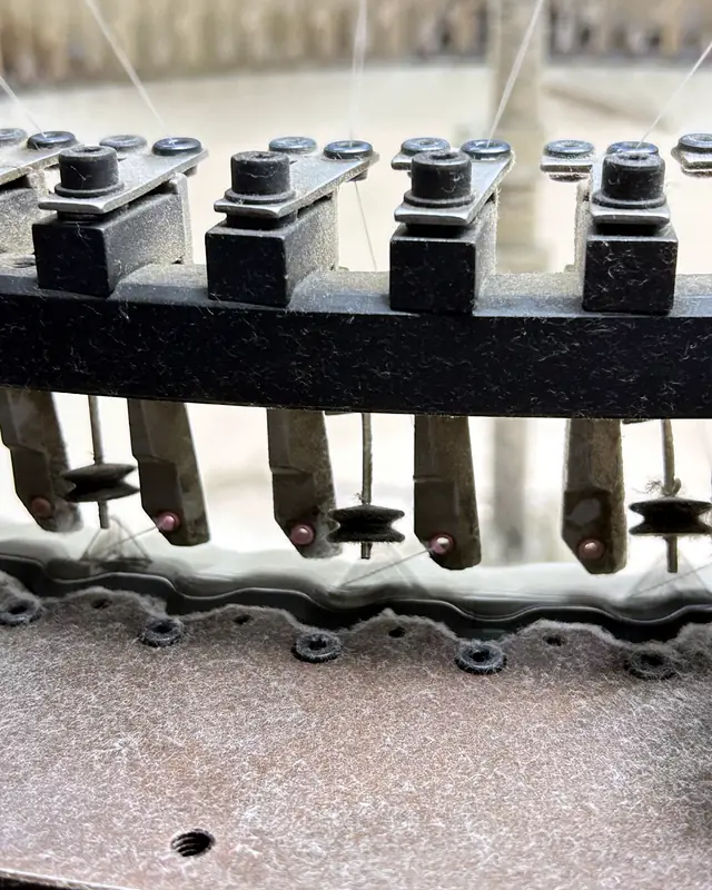 Close-up of needles forming knitted fabric during production